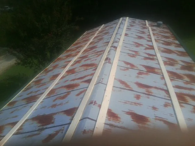 Rusted metal roof panels with new wood purlins before replacement — Storm Damage Roof Repair in Charlotte by Roofing Brothers