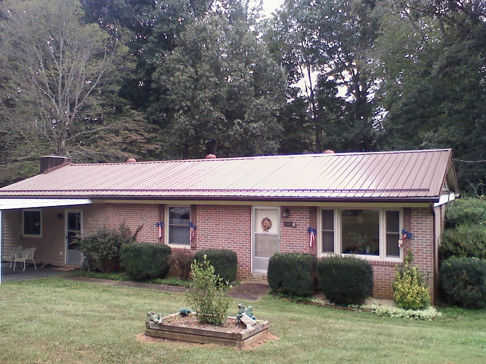 Bronze metal roof on a brick ranch home with a carport in Charlotte