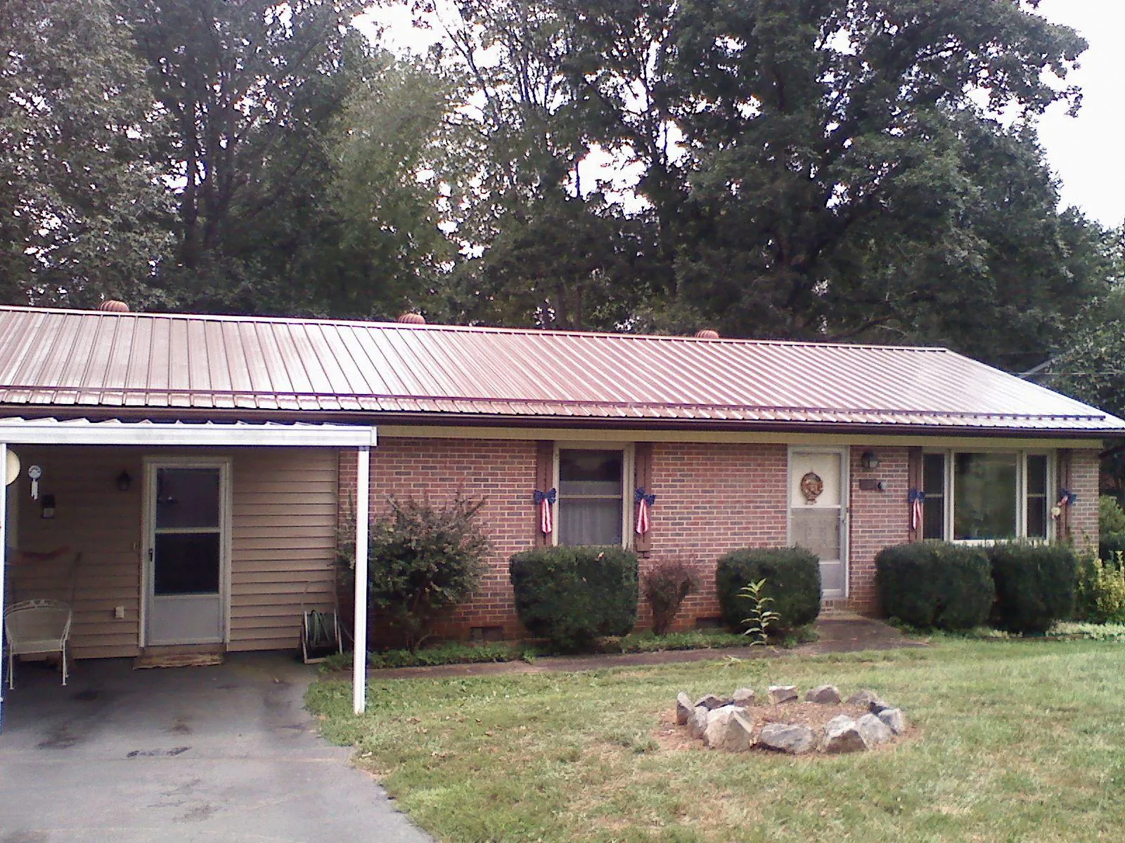 Bronze metal roof and carport on a brick ranch home — Roof Repair work by our crew in Charlotte