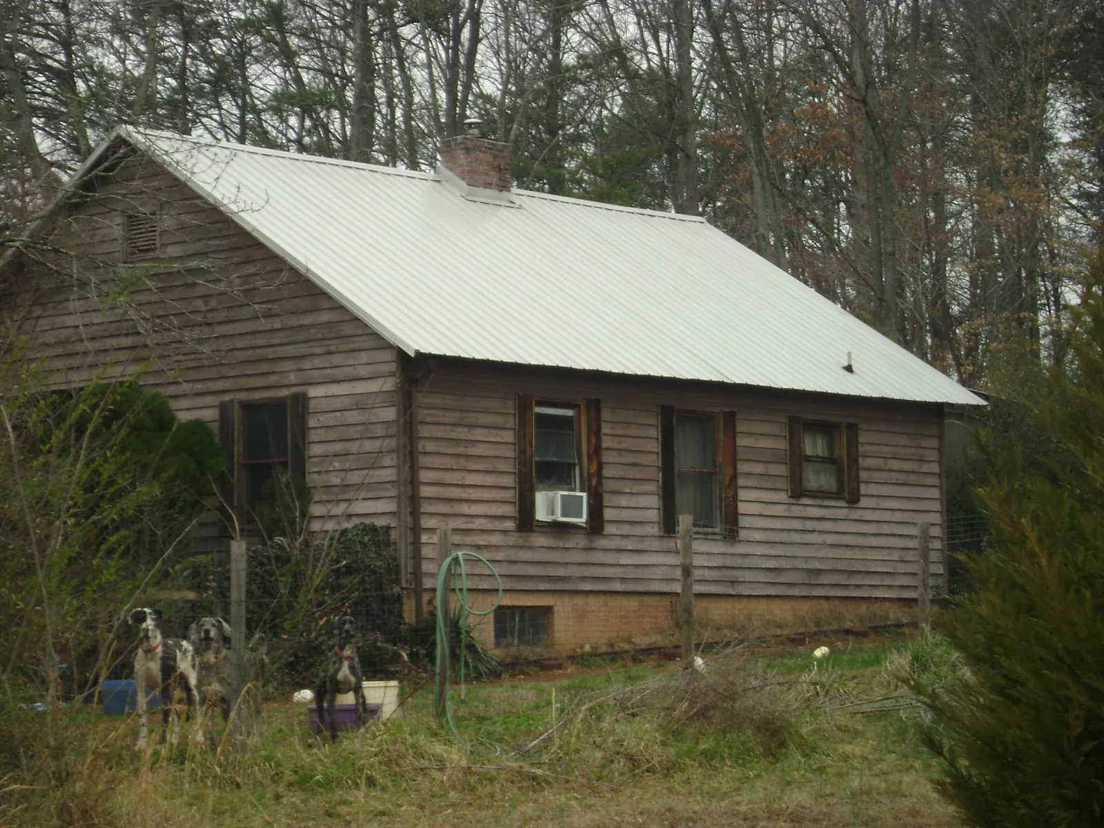 White metal roof on an old wood sided farmhouse, from a Metal Roof Installation job in Charlotte